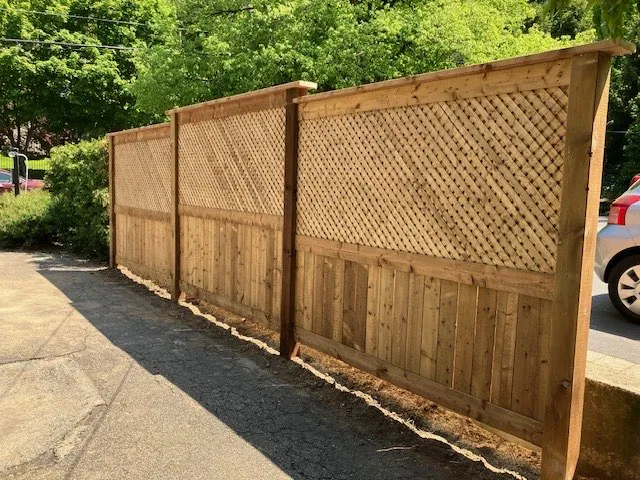 Lattice-topped wood privacy fence running along a driveway, built by Walnut Creek in Hamilton